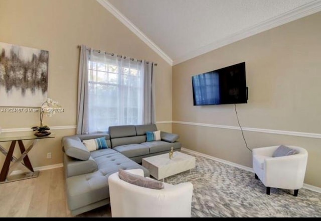 living room featuring lofted ceiling, wood-type flooring, and ornamental molding