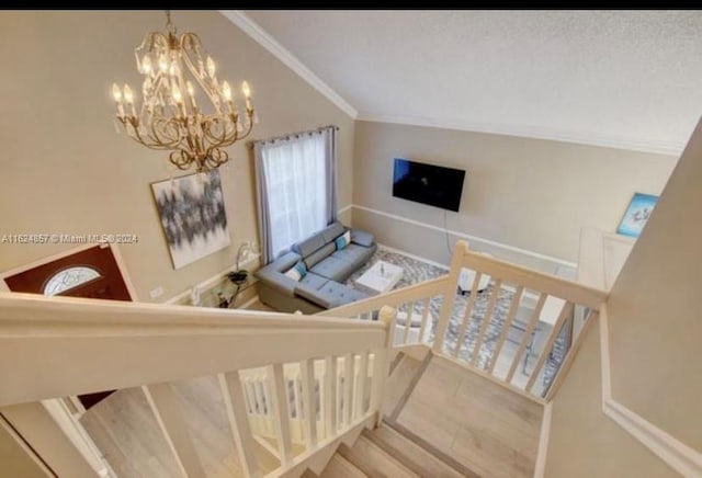 stairway featuring a notable chandelier, ornamental molding, and a textured ceiling