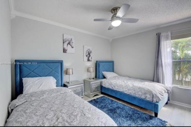 bedroom featuring crown molding, a textured ceiling, ceiling fan, and wood-type flooring