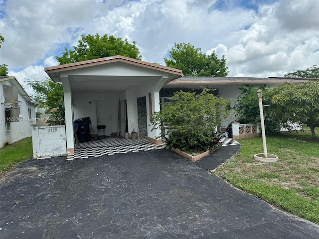 view of parking with a carport and a lawn