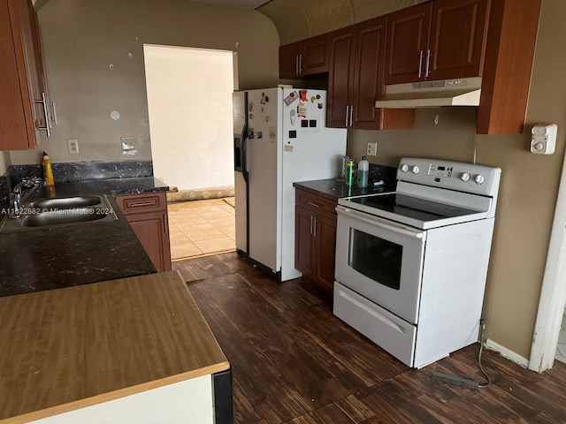 kitchen with dark hardwood / wood-style floors, white appliances, and sink