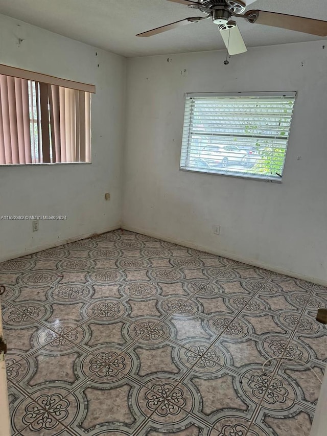 unfurnished room with tile patterned floors, a healthy amount of sunlight, and ceiling fan