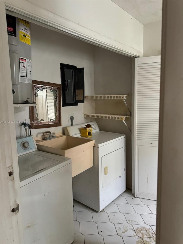 laundry area featuring light tile patterned flooring, water heater, washing machine and clothes dryer, and electric panel