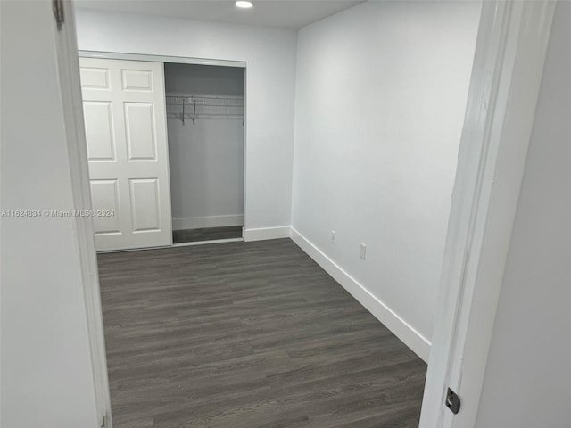 unfurnished bedroom featuring a closet and dark hardwood / wood-style flooring