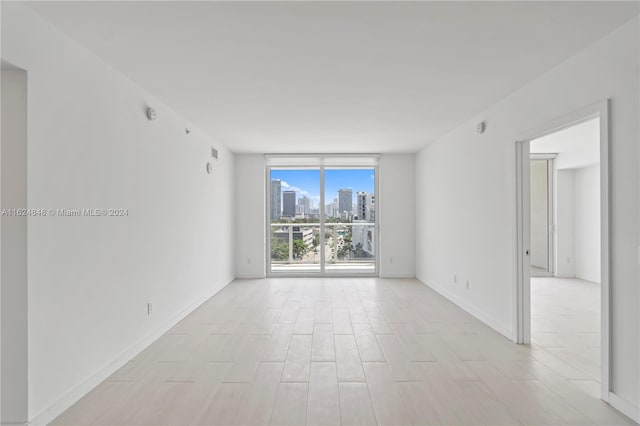 4250 Biscayne Blvd Unit 1018, Miami, FL 33137 - unfurnished room with a wall of windows, a skyline view, and light wood-style flooring