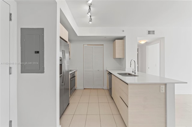 kitchen featuring track lighting, sink, kitchen peninsula, light tile patterned floors, and electric panel