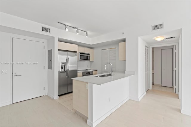 kitchen with light tile patterned floors, stainless steel appliances, track lighting, and sink