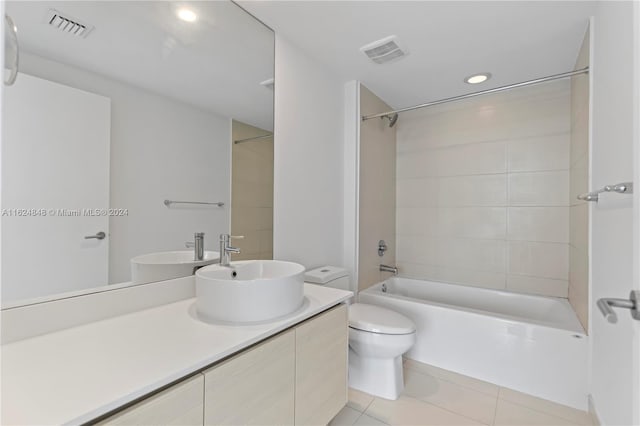 full bathroom featuring vanity, tiled shower / bath combo, toilet, and tile patterned floors