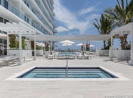 view of swimming pool featuring a patio area and a jacuzzi