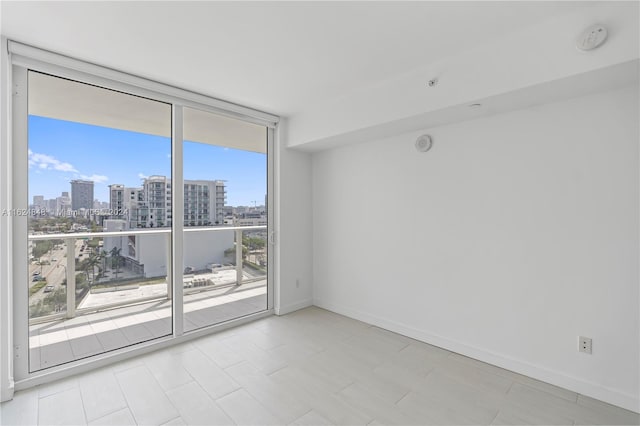 spare room with light tile patterned flooring and expansive windows