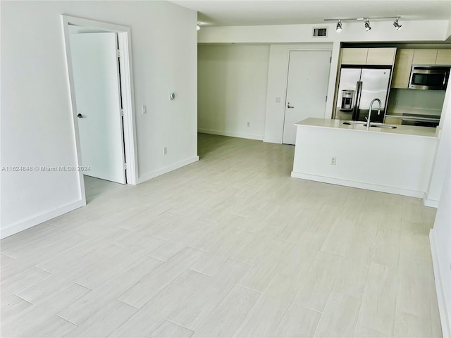 interior space featuring light hardwood / wood-style floors, sink, and track lighting