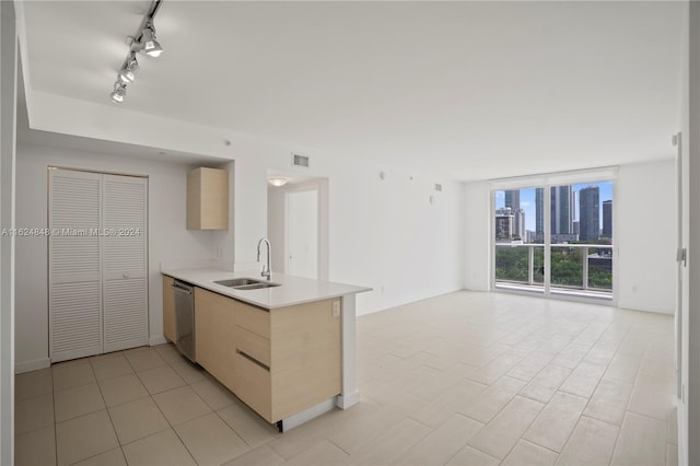 kitchen with sink, kitchen peninsula, track lighting, and light tile patterned floors