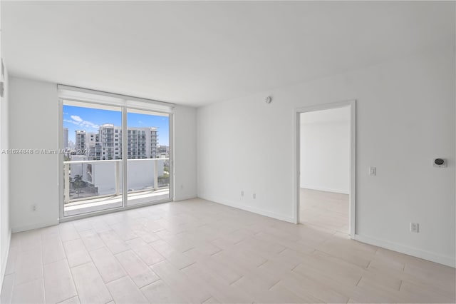 empty room featuring floor to ceiling windows and light tile patterned floors