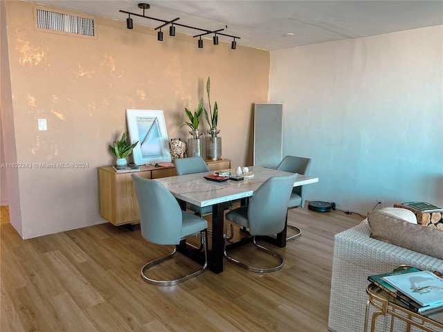 dining room featuring hardwood / wood-style floors and rail lighting