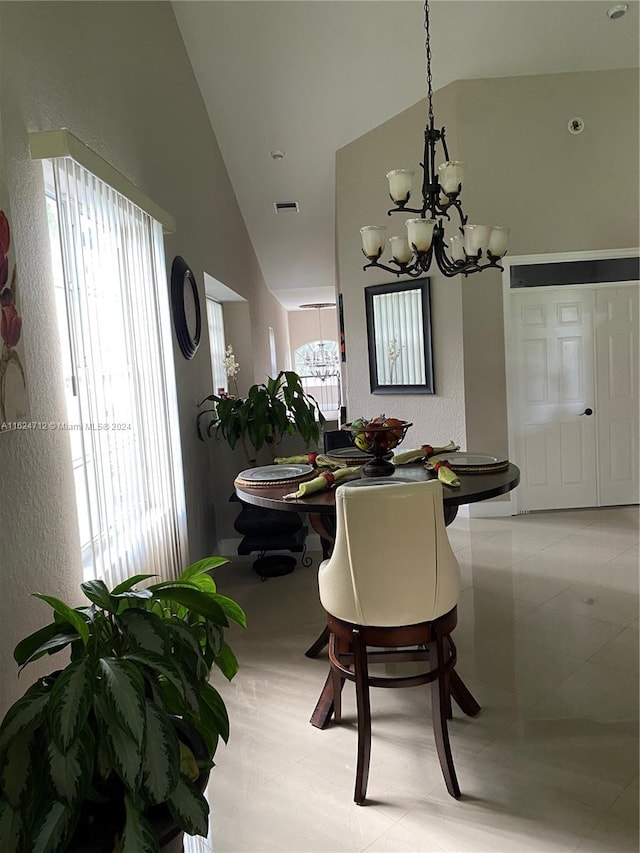 dining space with a healthy amount of sunlight, high vaulted ceiling, and a chandelier