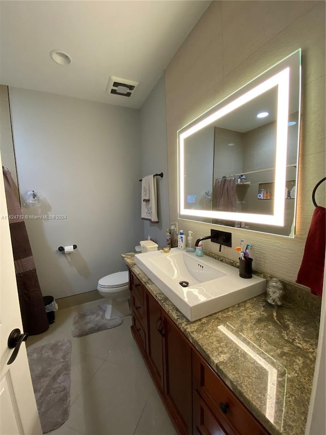 bathroom with vanity, backsplash, toilet, a shower with curtain, and tile patterned floors