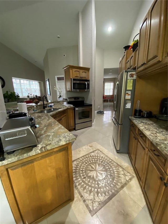 kitchen featuring appliances with stainless steel finishes, sink, high vaulted ceiling, stone counters, and light tile patterned flooring