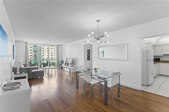 dining room with a notable chandelier, a textured ceiling, and hardwood / wood-style flooring