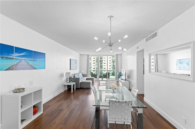 dining area with a notable chandelier, a textured ceiling, and dark hardwood / wood-style floors