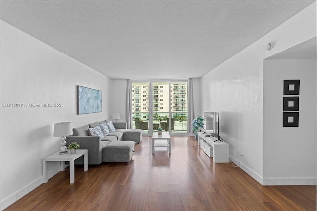 living room with dark hardwood / wood-style floors, floor to ceiling windows, and a textured ceiling