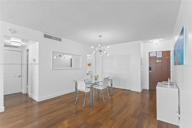 dining area featuring a notable chandelier, a textured ceiling, and dark wood-type flooring