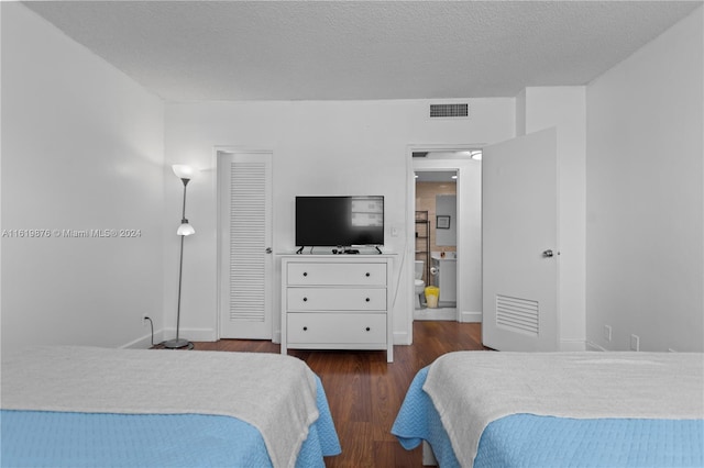 bedroom featuring a textured ceiling and dark hardwood / wood-style flooring