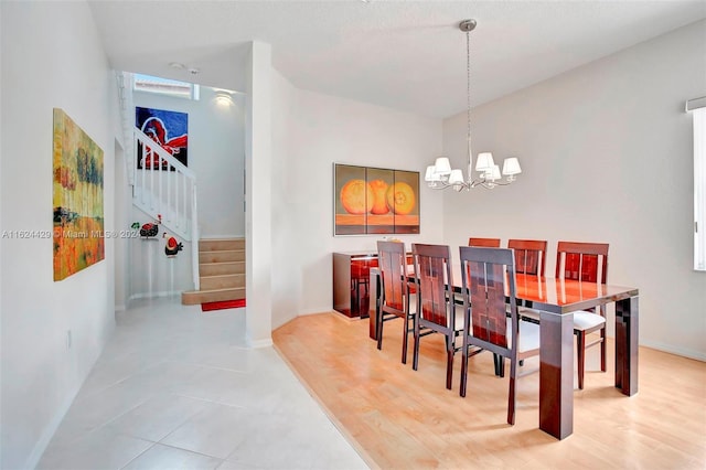 dining space featuring stairs, an inviting chandelier, and baseboards