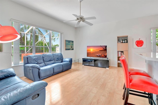 living room with a ceiling fan, wood finished floors, and baseboards