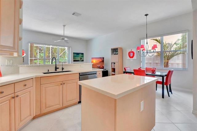 kitchen with ceiling fan with notable chandelier, a sink, light countertops, dishwashing machine, and hanging light fixtures