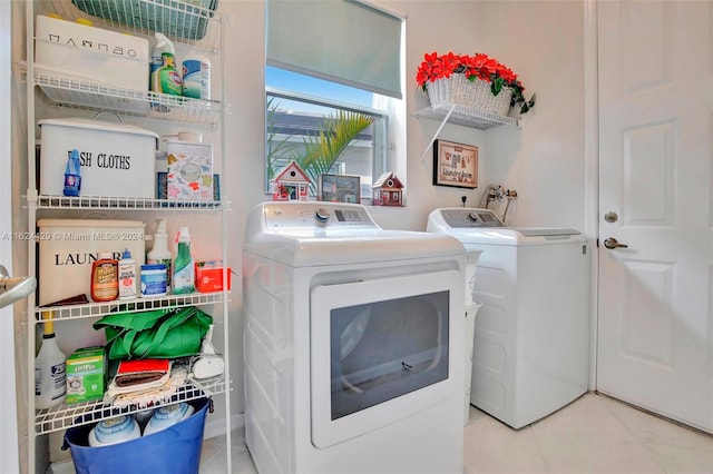 washroom with tile patterned floors, washing machine and dryer, and laundry area