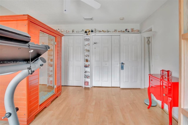 interior space with visible vents, light wood-type flooring, and ceiling fan