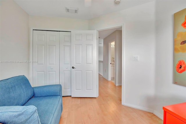 sitting room featuring baseboards, visible vents, and light wood-type flooring