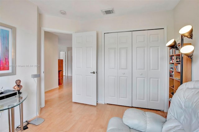 bedroom with visible vents, baseboards, light wood-style floors, and a closet