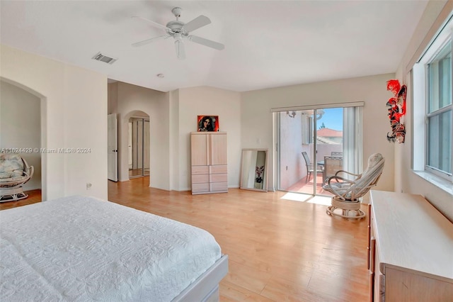 bedroom featuring access to exterior, visible vents, light wood-type flooring, arched walkways, and a ceiling fan