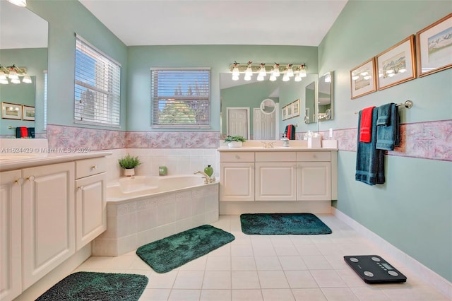 bathroom featuring tile patterned floors, two vanities, a garden tub, and a sink