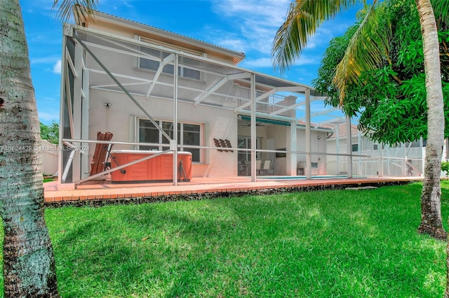 rear view of property with stucco siding, a patio, a yard, glass enclosure, and an outdoor pool