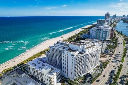 drone / aerial view with a water view and a beach view