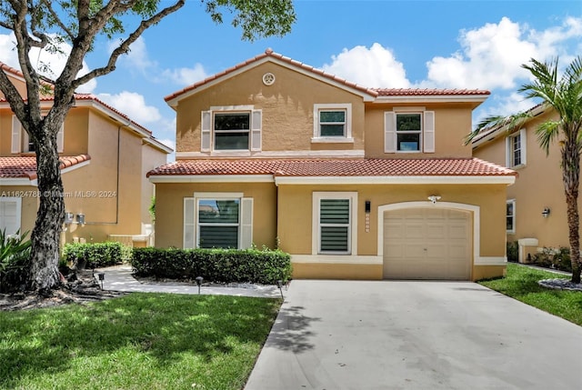 mediterranean / spanish-style home featuring a garage and a front yard