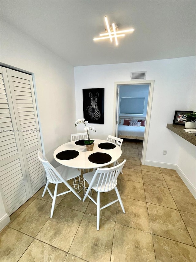 dining space featuring a notable chandelier and light tile patterned floors