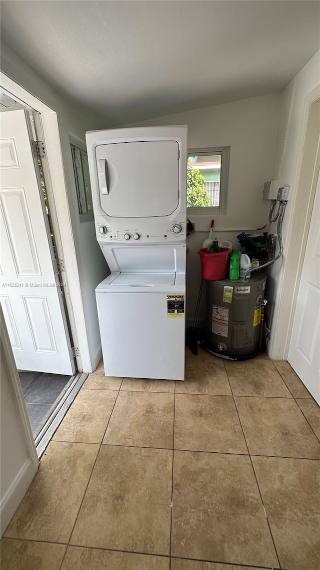 clothes washing area featuring light tile patterned flooring and stacked washer / drying machine