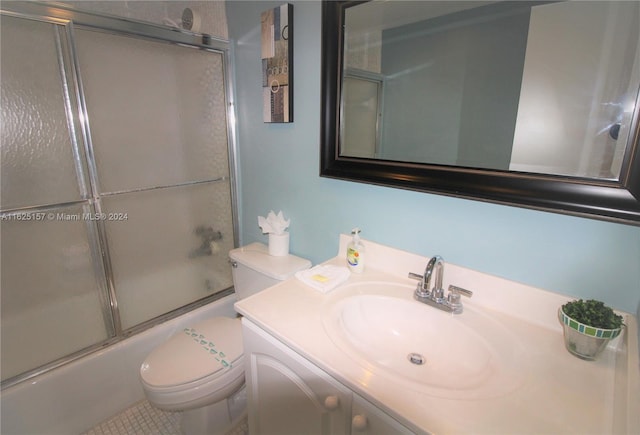 full bathroom featuring vanity, combined bath / shower with glass door, tile patterned flooring, and toilet