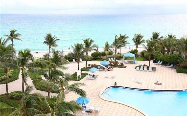 view of swimming pool featuring a water view and a patio area