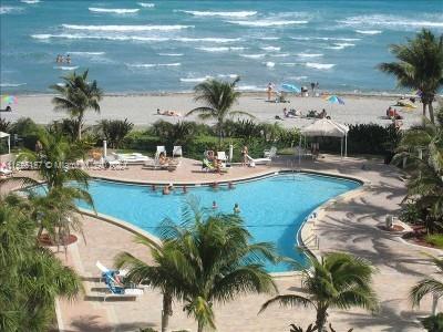 view of swimming pool with a patio area and a beach view