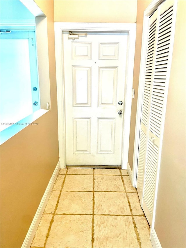 doorway with light tile patterned flooring