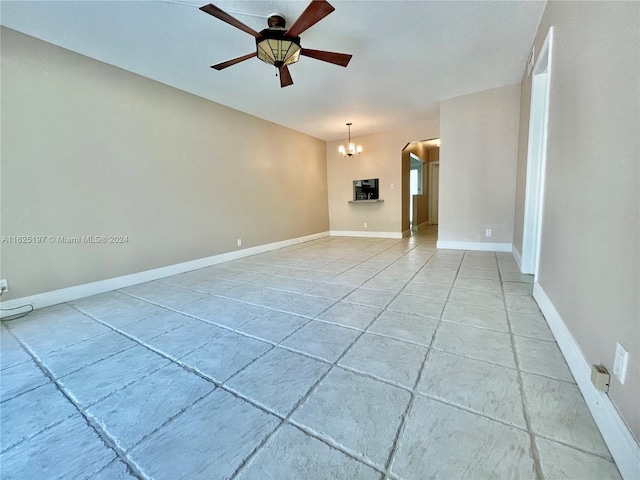 unfurnished living room with ceiling fan with notable chandelier