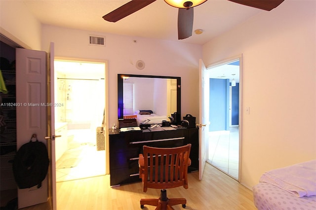 bedroom with connected bathroom, ceiling fan, and light wood-type flooring