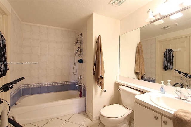 full bathroom with tiled shower / bath combo, toilet, vanity, tile patterned floors, and a textured ceiling