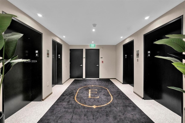 hall with elevator and light colored carpet