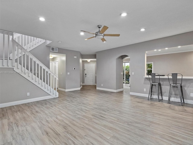 unfurnished living room with light wood-type flooring and ceiling fan