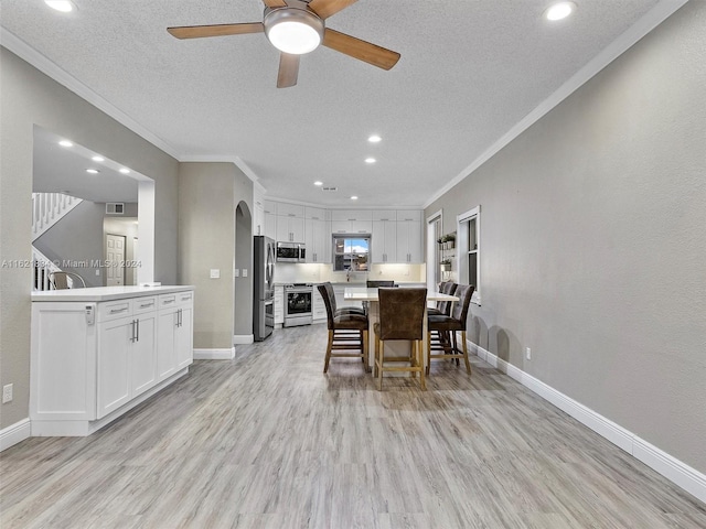 dining area with light wood-type flooring, ceiling fan, and crown molding